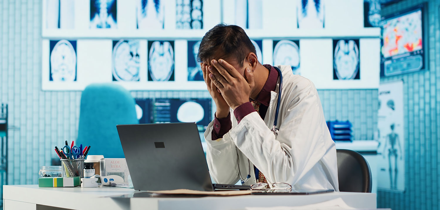 Stressed physician working late at night in a hospital, illustrating the serious consequences and pressure caused by medical lab errors.